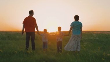 Mutlu aile takımı el ele tutuşup ellerini kaldırsın. Ekip çalışması. Aile eğlencesi. Gün batımında farklı yaşlarda bir grup insan ellerini havaya kaldırıyor. Ortaklık ve iş konseptine yardım.