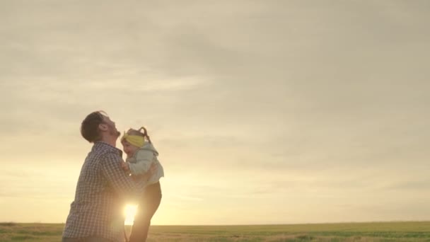 Padre e hijo juegan, se ríen y se abrazan juntos. Papá vomita una hija feliz en el cielo azul. appy familia viaja. Bebé en los brazos del padre. Papá día libre. El concepto de una familia feliz — Vídeos de Stock