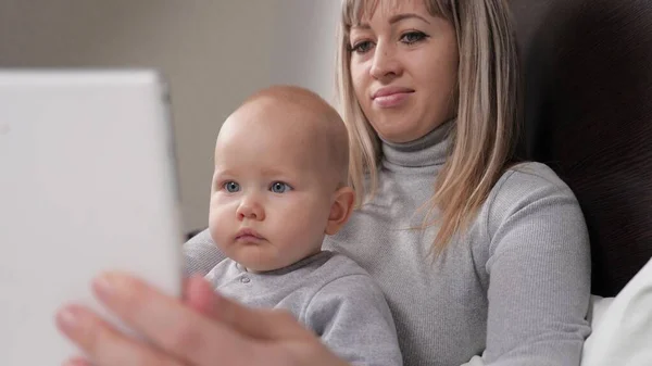 Evde bilgisayar tabletiyle aile tatili. Çocuk, çocuk, kız, bebek, oğlan, öğreniyor, tablete bakıyor. Mutlu aile, ebeveyn, anne, küçük çocuk, oğul, kız dijital tablet kullanarak eğleniyorlar. — Stok fotoğraf