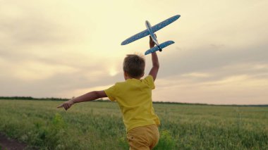 Çocuk oyuncak uçakla buğday tarlasında koşuyor. Parkta koşuşturan, yazın oyuncak uçakla oynayan mutlu bir çocuk. Mutlu bir aile. Çocuk uçmayı hayal ediyor. Tasasız çocuk dışarıda oynuyor.