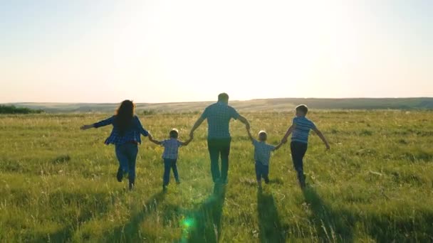 Happy sons, children, mom and dad run, play, rejoice, enjoy nature in summer. Happy family team, run together holding hands in park. Teamwork of people. A group of people of different ages at sunset. — Stock Video