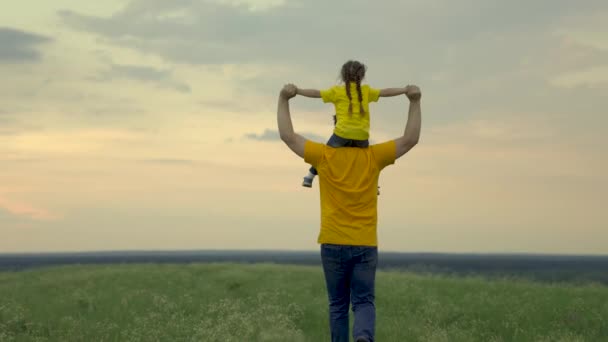 Father with child, his daughter dreams of flying, family runs on green grass in park at sunset. A happy family. Weekend in nature, dad and daughter are playing together. Happy family and togetherness — Stock Video