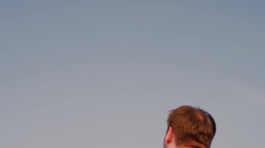 Babam mutlu oğlunu mavi gökyüzüne fırlattı. Baba ve küçük çocuk parkta oynuyorlar, gülüyorlar ve sarılıyorlar. İyi yolculuklar. Bebek ebeveynlerin kollarında. Babam izinli. Mutlu aile kavramı