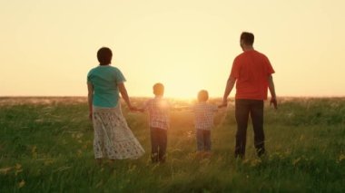 Aile eğlencesi. Mutlu aile takımı el ele tutuşup ellerini kaldırsın. Ekip çalışması. Gün batımında farklı yaşlarda bir grup insan ellerini havaya kaldırıyor. Ortaklık ve iş konseptine yardım.