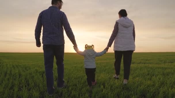 Happy rodina procházky v parku drží ruce v létě při západu slunce. Rodinná dovolená. Mami, tati, dcera si hrají na hřišti, dítě drží rodiče za ruce. Týmová práce. Šťastné dětství, rodinné vzdělání — Stock video