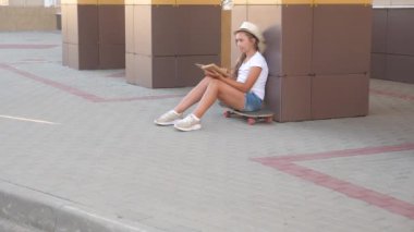 Elinde ders kitabı olan bir kız öğrenci sokakta kaykayla yürüyor. Modaya uygun bir kız, şehirdeki okul binasının yanında kitap okuyor ve kaykayın üzerinde oturuyor. Ergen ders çalışıyor. Eğitim