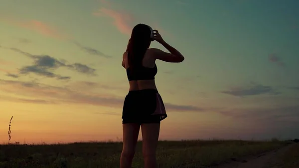 Mujer joven libre corre en verano en el parque al amanecer escucha música con auriculares. Entrenamiento de trotar. Correr sano y concepto de ejercicio al aire libre. Escuchar música sin Internet y practicar deportes — Foto de Stock