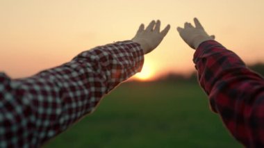 Mutlu aile üyeleri ellerini güneşe uzatıyor, takım çalışması. Yazın doğadaki insanlar gün batımında ellerini kaldırırlar. İnsanların güneşe ve tatile dua ettiği bir siluet. Din, birlikte dua.