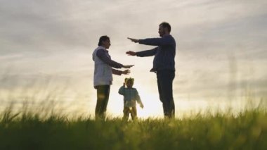 Mutlu aile küçük kızıyla oynuyor, evde güneşin altında aile sembolü. Annem, babam ve onlar bir çocuğun başının üstündeki evin çatısını elleriyle tasvir ediyorlar. Paylaşılan bir evin hayalini kur. Ev yapımcıları