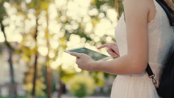 Öğrencilerin elleri tabletin ekranına dokunuyor. Kentte kaldırımda yürüyen tabletle çalışan serbest çalışan bir kadın. Şehir sokaklarında dijital tablet baskı mesajları kullanan iş kadını. — Stok video