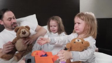 Mutlu aile evde oynar, çocuklar ağlar ve güler anne ve baba odada kızlarıyla oynar. Bebekler ağlar, ebeveynleri onları oyuncaklarla sakinleştirir. Aile eğitimi, neşe ve gözyaşı, çocuk duyguları
