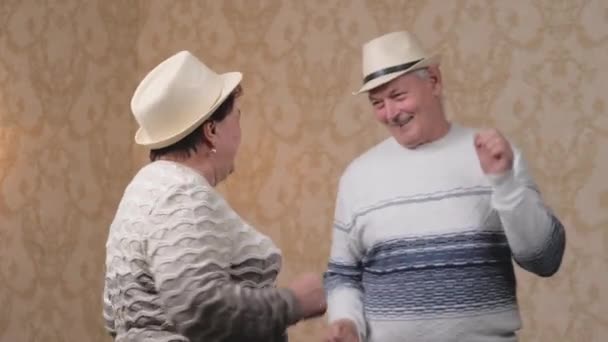 Feliz pareja de casados maduros bailando en casa en la habitación, riendo y hablando. Hermoso romántico ancianos de mediana edad abuelos tienen descanso, divertirse juntos, celebrar, disfrutar del cuidado, el amor, la ternura. — Vídeo de stock