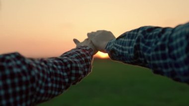 Mutlu insanlar yazın gün batımında parkta ellerini kaldırıp uzatıyorlar. Evli çift, erkek, kadın elini güneşe uzatıyor, takım çalışması. İnsanların güneşe ve tatile dua ettiği bir siluet. Din, birlikte dua.