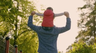 Baba ve çocuk kızlarıyla uçmayı hayal eder, aile gün ışığında sokakta yürür. Baba ve kızı parkta oynuyorlar, bebek babalarının omuzlarında oturuyor. Mutlu bir aile, birliktelik. Hafta Sonu