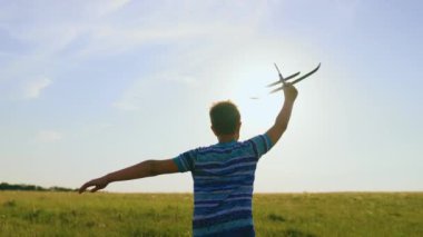 Çocuk elinde oyuncak uçakla yaz tarlasında gün batımında koşuyor. Çocuk uçmayı hayal ediyor. Parkta koşan, doğada oyuncak uçakla oynayan mutlu bir çocuk. Tasasız çocuk dışarıda oynuyor.
