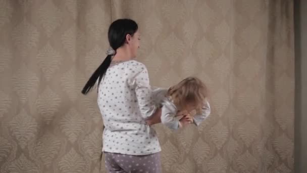 Bébé et maman s'amusent ensemble dans la chambre. Maman joue avec l'enfant, fille rit et tourne dans ses bras, enfant mignon est heureux à la maison. Charmante fille vole avec plaisir et joue avec sa mère — Video