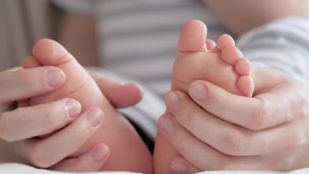 Nogi dziecka, mama przytuli dziecko rękami. Szczęśliwa matka i jej dziecko bawią się razem. Dziecięce stopy w rękach matek. Zdrowe niemowlę i mamusia. Szczęśliwa rodzina. Szczęśliwego dzieciństwa — Wideo stockowe