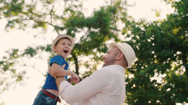 Pappa cirklar runt i armarna på sin lyckliga son i parken. Far och barn leker i skogen, skrattar och kramas tillsammans. Trevlig familjeresa. Barnet är i föräldrarnas famn. Pappor ledigt idag. Lycklig familj — Stockfoto