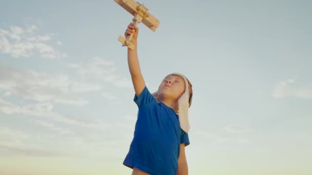 Fils rêve de voler, petit pilote. Joyeux enfant, mon garçon, jouant avec un avion jouet devant le ciel. L'enfant tient dans sa main un avion jouet. Une famille heureuse joue dans le parc. Enfant insouciant jouant à l'extérieur — Video