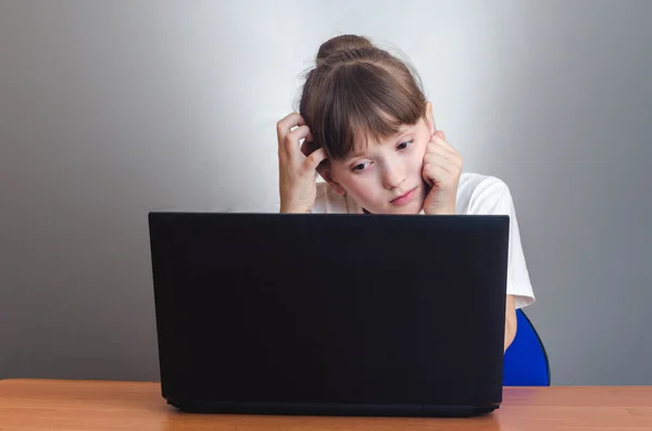 Chica mirando a un ordenador portátil — Foto de Stock