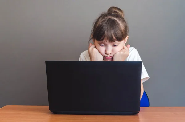 Chica mirando a un ordenador portátil — Foto de Stock