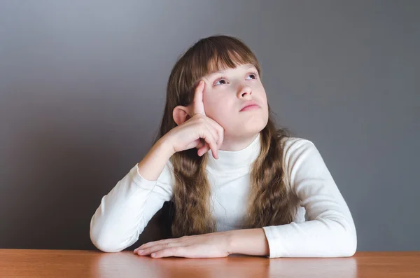 The girl looks up and thinks — Stock Photo, Image