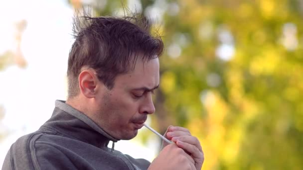 Чоловік курить цигарку і довго кашляє — стокове відео