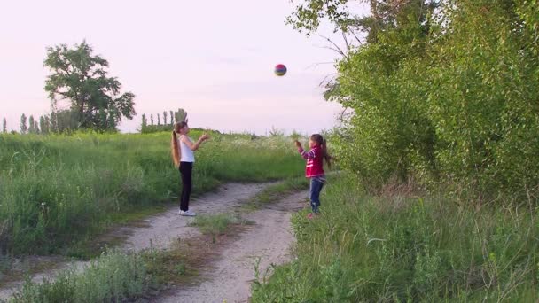 A menina jogar um ao outro uma bola — Vídeo de Stock