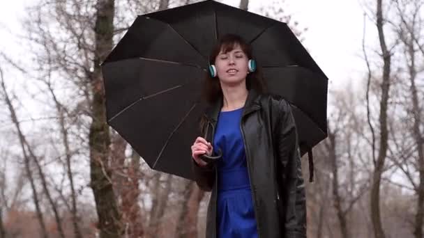 La femme sous la pluie écoute de la musique — Video