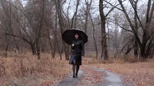 De vrouw in zwarte glazen gaat op de weg — Stockvideo