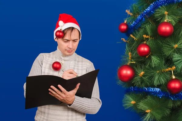 Mannen i en röd mössa ser ut i mappen svart — Stockfoto