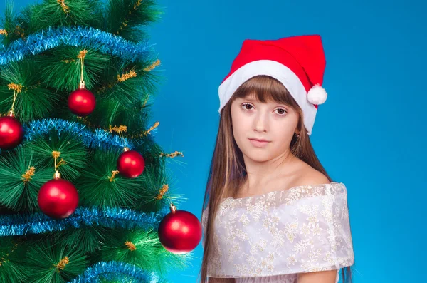 A menina triste em um vestido e um gorro vermelho custa em um belo Novo Y — Fotografia de Stock