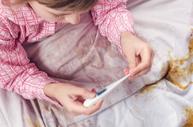 The girl looks at a thermometer clipart