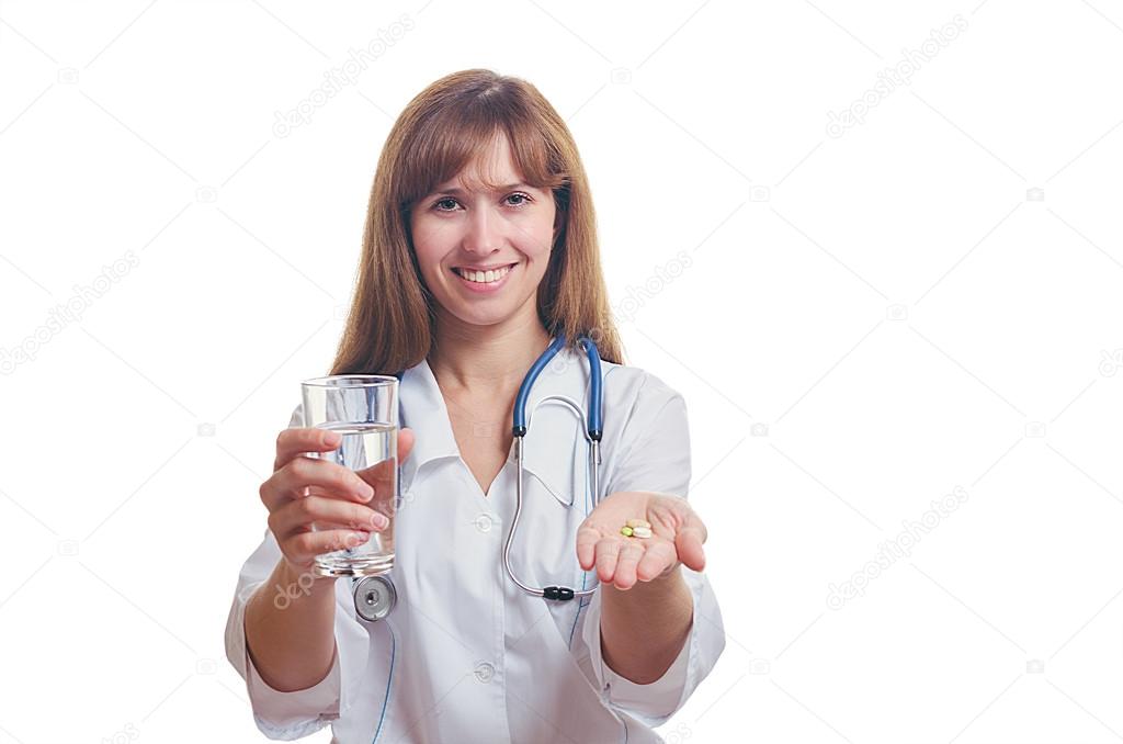 The doctor holds a glass with water and tablets in hand.