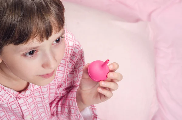 The girl in a pajamas holds an enema in hand — Stock Photo, Image