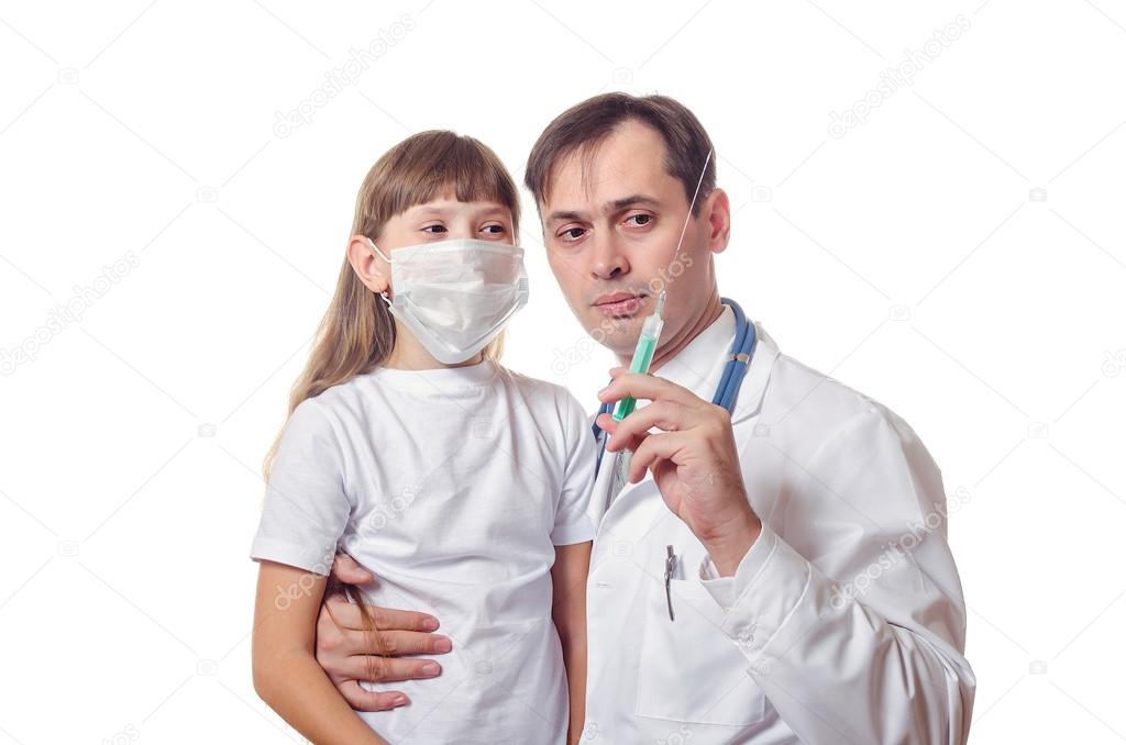 The doctor shows to the child a syringe 
