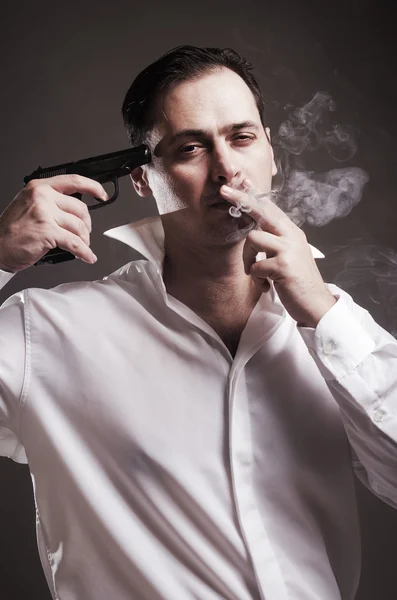 The man smokes holding at with authority gun — Stock Photo, Image