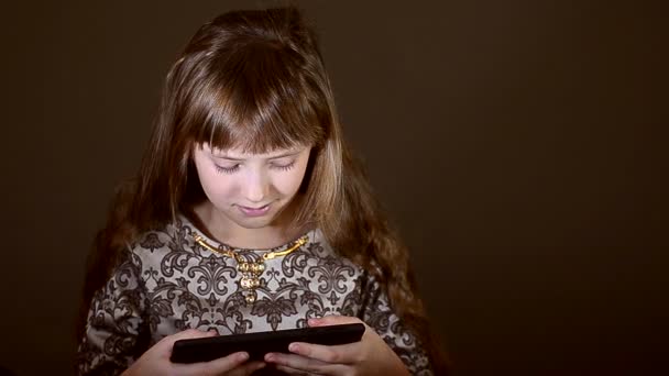 La chica en un vestido juega una almohadilla — Vídeos de Stock