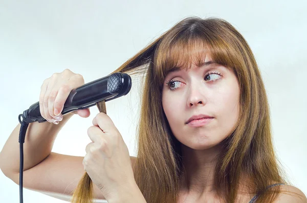 Kadın saç kıvırmak demir düzeltiyor