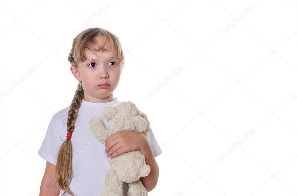 The sad girl holds a bear in hand