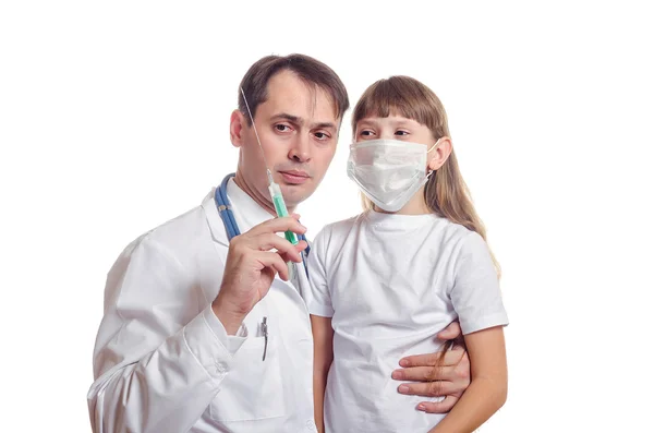 医者は子供に注射器を示しています。 ロイヤリティフリーのストック画像