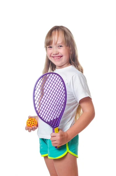 The girl holds a toy racket and a ball in hand — Stock Photo, Image