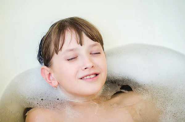 Fata se scaldă într-o baie cu spumă și ochii închiși . — Fotografie, imagine de stoc