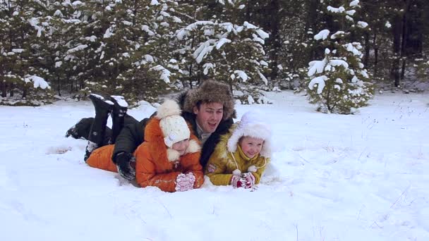 El padre con hijos yace en la nieve — Vídeos de Stock