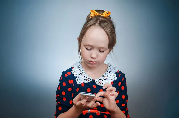 La ragazza gioca con il telefono bianco — Foto Stock