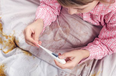 The girl looks at a thermometer clipart