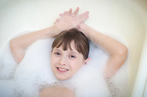 A lány abban rejlik, hogy egy fürdőszoba hab és mosoly — Stock Fotó