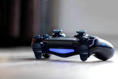 Tahta bir yüzey üzerindeki Playstation 4 kontrolörünün yakın plan portresi. Alınıp oyuna başlamaya hazırım..