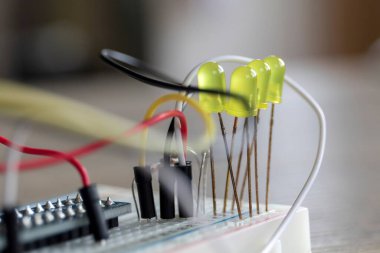 Bazı elektronik aletlerin portresi, üzerinde LED 'ler ve kablolar olan bir ekmek tahtası..