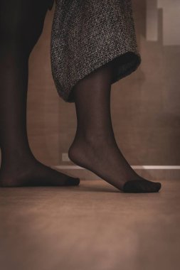 A portrait of a foot in sexy black pantyhose of a girl pulling up her skirt. The nylon is reinforced at the toes. clipart